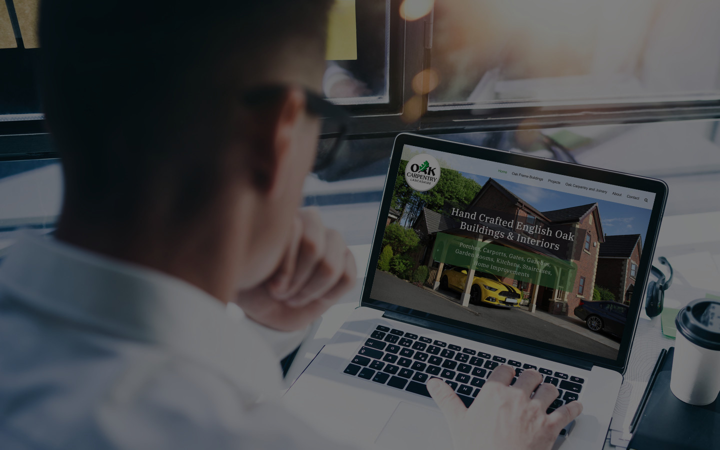 Orangebox Digital, Web Design, Designer browsing on Laptop, viewing Oak Carpentry Lancs Website